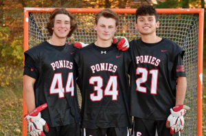 Senior Captains Alex Corbett, Gunner Arnes and Isaac Albers stand together in front of the net getting ready to lead the lacrosse team in a strong season. They hope to have a strong season and team this year.
