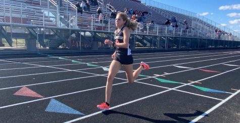 Senior Ana Weaver crosses the finish line of the 1 mile. Weaver completed a time of 5 minutes flat at her home track.