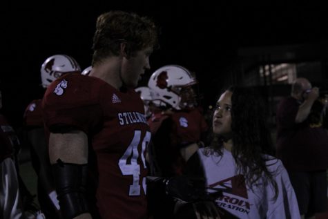 Senior Grace Volkman connects with junior player Charlie Gleason on the sidelines during the game. Grace was recently given the title of the 2021 football manager and she spends practices and game days working hard.