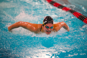 Junior grader Lucy Siedschlag swims the 100 yard butterfly at a dual meet against Park. Siedschlag takes a deep breath as she fights for first place with a time of 1:05.97. 