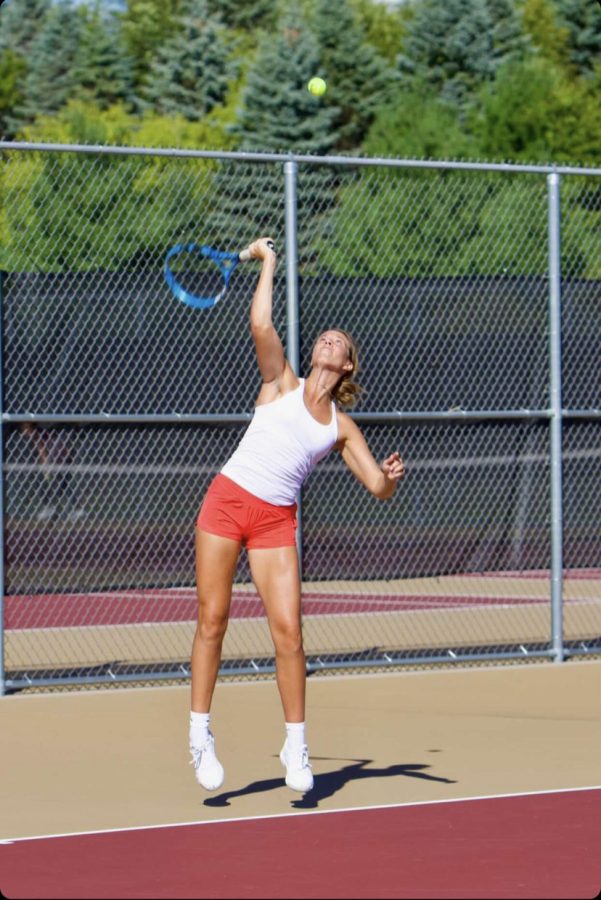 Senior player Lizzie Holder serves at a varsity match. Jana Myers and Lizzie Holder recently placed third in section finals.