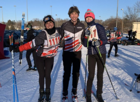 Senior Elly Flaherty and Junior Addie Smitten prepare to start their Nordic ski race, and congratulate Junior Kyle Och on his race he just finished.