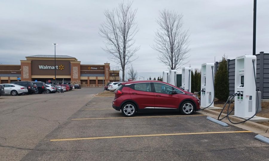 A+red+electric+car+is+hooked+up+to+a+charging+station+outside+of+Walmart+off+of+Hudson+Road+in+Woodbury%2C+MN.