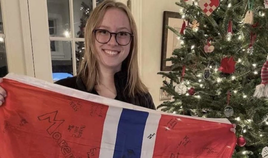 Senior Marit Hegstad is standing with a Norweign flag from camp next to her Christmas tree.