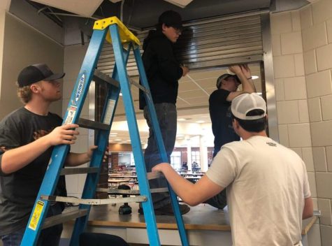 Seniors Henry Redfield, Jake Magner, Nick Magner, Montana Weeks and Michael Dollerschell work to remove a rollup window.
