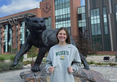 Avery Lorinser holding her sweatshirt in front of NMU campus.