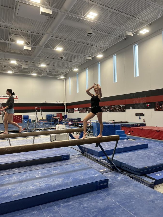Evelyn Johnson is at practice going through her beam routine. She is practicing her upcoming meet. 