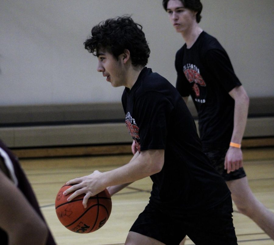 Sophomore Mason Mora-Clark dribbles the ball down the court during the Unified basketball game. Mora-Clark is playing his second year of adapted basketball, helping the team to a state title in 2022.