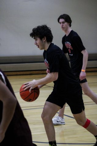 Mason Mora-Clark dribbles the ball down the court during the Unified basketball game. 