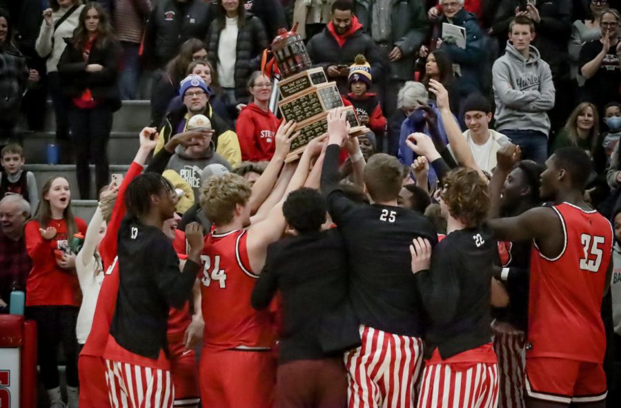 Stillwater Basketball team holding up Oil Can trophy