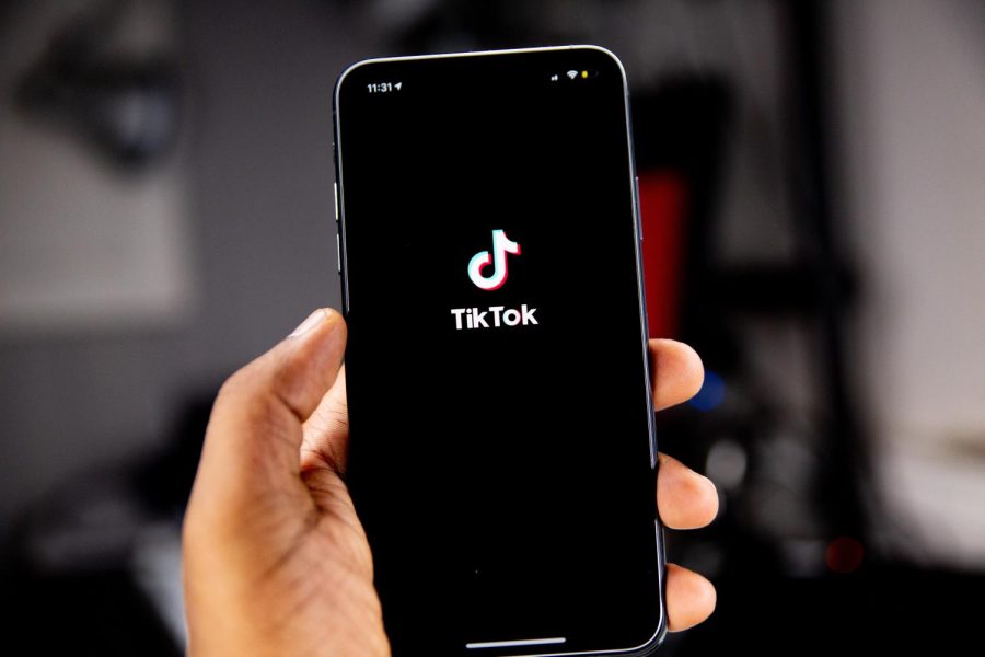 Somebody launching TikTok, a social media platform, on their iPhone.