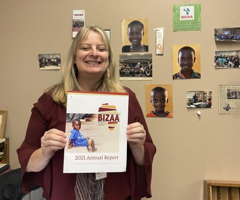 Kirsten Carter standing in front of a collage of the students the high schools BIZAA supports.