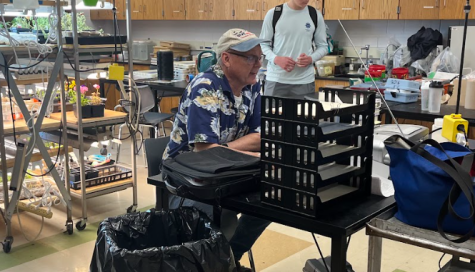 Andrew Weaver sits helping guide students through their final projects. He lets students choose whatever they want for their final research project. He sets the guard rails and helps when needed, but other than that lets the students have freedom in the project. 