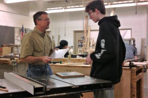 Technology teacher Todd Kapsner helps student make project in his woodworking class. Kapsner teaches woodworking among other industrial tech classes at the school.