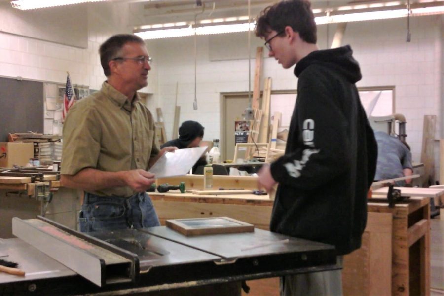Technology+teacher+Todd+Kapsner+helps+student+make+project+in+his+woodworking+class.+Kapsner+teaches+woodworking+among+other+industrial+tech+classes+at+the+school.