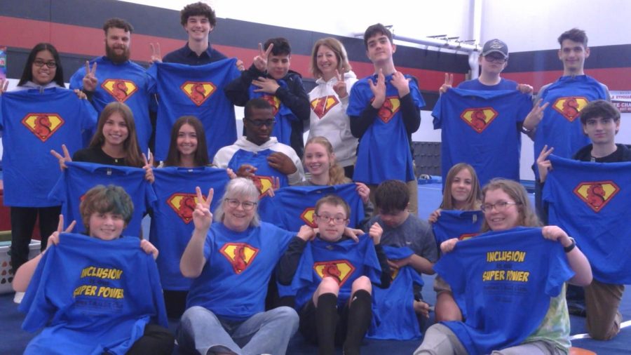 Mrs. Harrison and her crew of Unified students, hold up their inclusion t-shirts. Harrison and her crew created inclusion is my super power shirts to spread inclusion amoung the school and community.