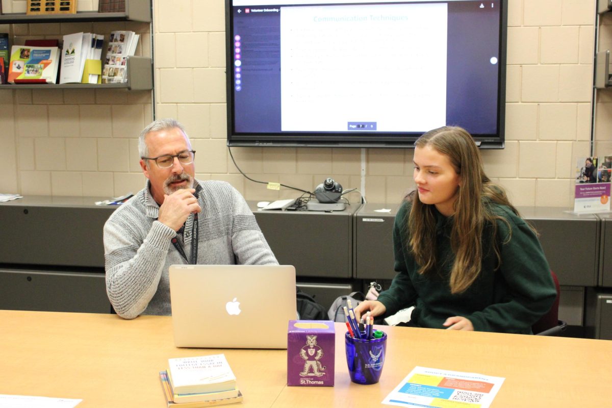 Junior Elise Dieterle and Bob Manning, Career and Pathways Coordinator, give a demonstration of what students can expect a meeting with a senior at Boutwells for Adopt-A-Grandparent at their information meeting to get prepare for this year. They share what students should and should not say when members participate.