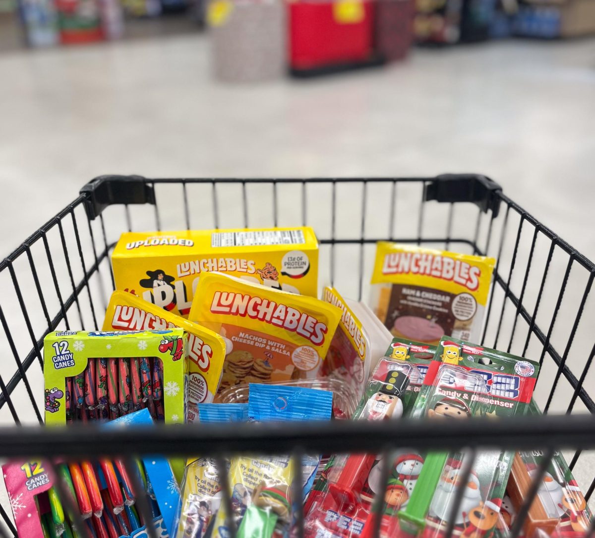 A shopping cart is filled with highly processed and unhealthy foods available at any grocery store. As Christmas candy shopping is on the rise this time of year, it might be worth it to take a second look at what is actually in classic favorites such as candy canes and Pez. 