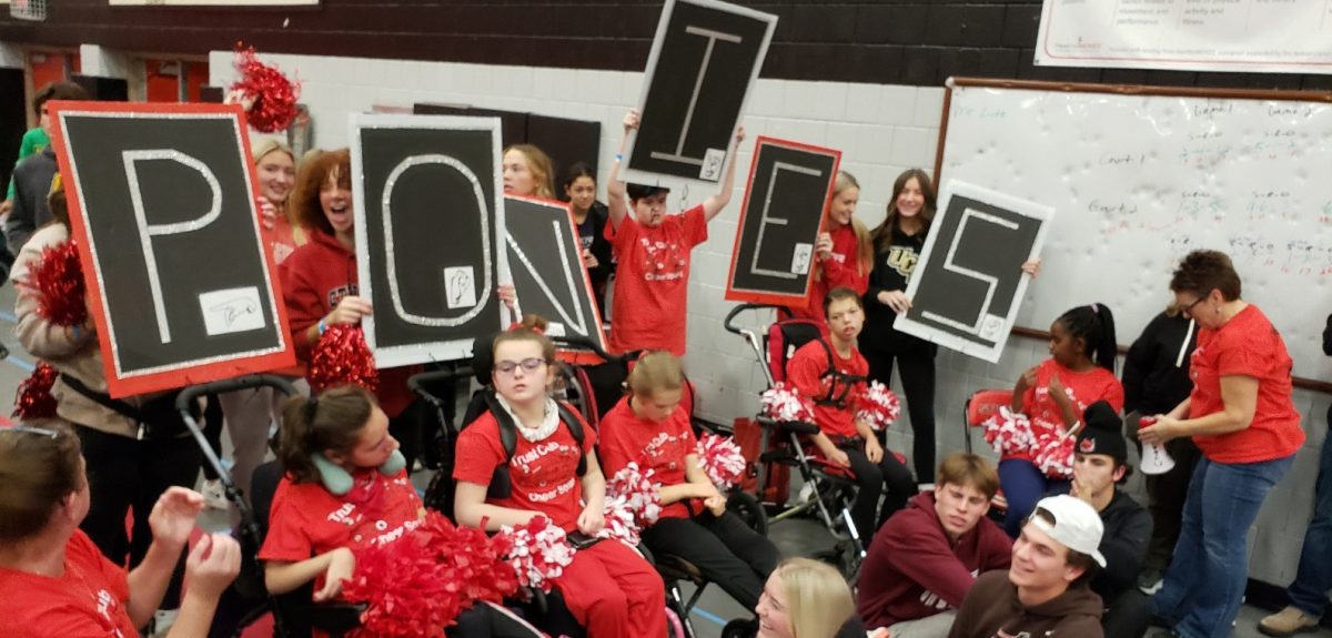 Trust Club Cheer Squad debuts their first inclusive cheer at the adapted soccer state tournament. Assistive technology makes it possible for students who communicate differently to be a part of the holler back cheer.