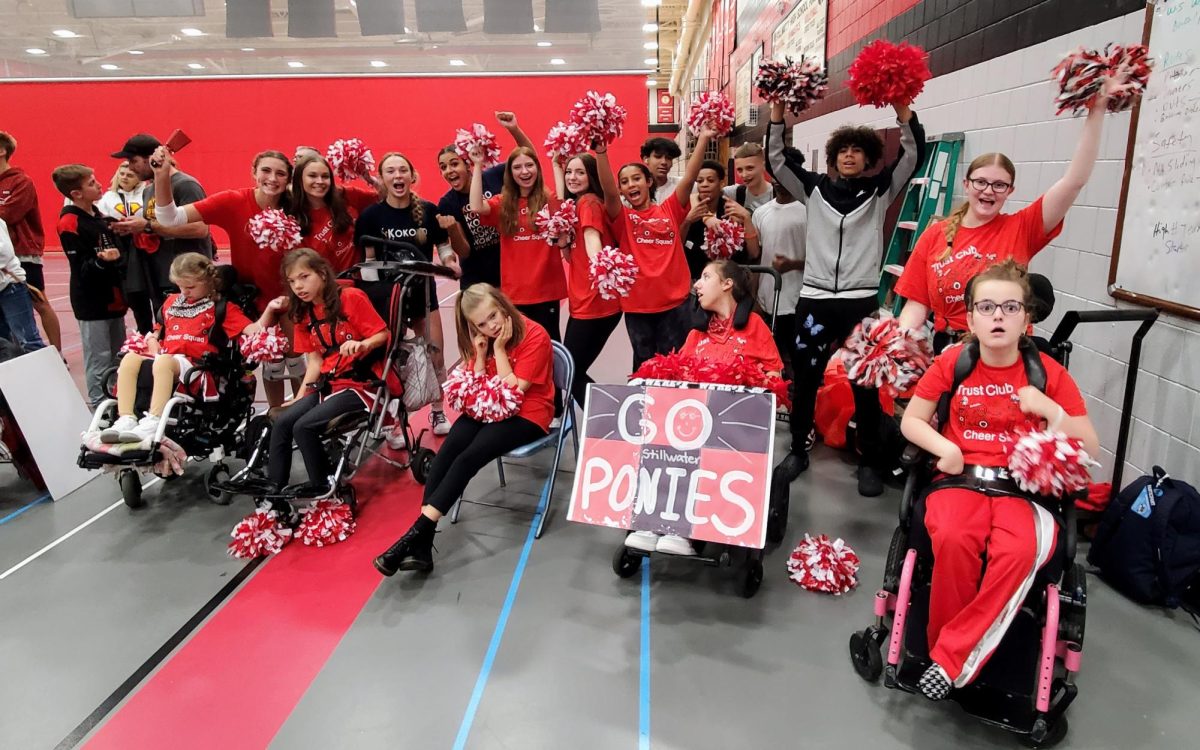 The cheer squad  debuts their adapted cheer at the adapted soccer state tournament. Assistive technology promotes  inclusion for those who communicate differently and gets the fans involved.