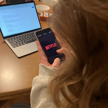 Senior Kaitlyn Ginkel opens the Netflix app on her phone. As the #1 streaming platform in the U.S, Netflix has become the go-to media intake for most teenagers and adults. 