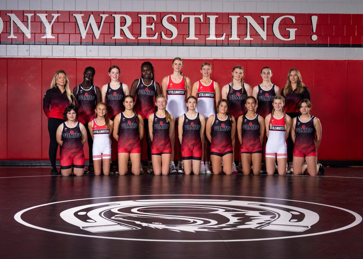 The entire girls wrestling team poses for a team photo in the wrestling gym at the beginning of the season. The team consists of players from all grades, including middle school wrestlers. 