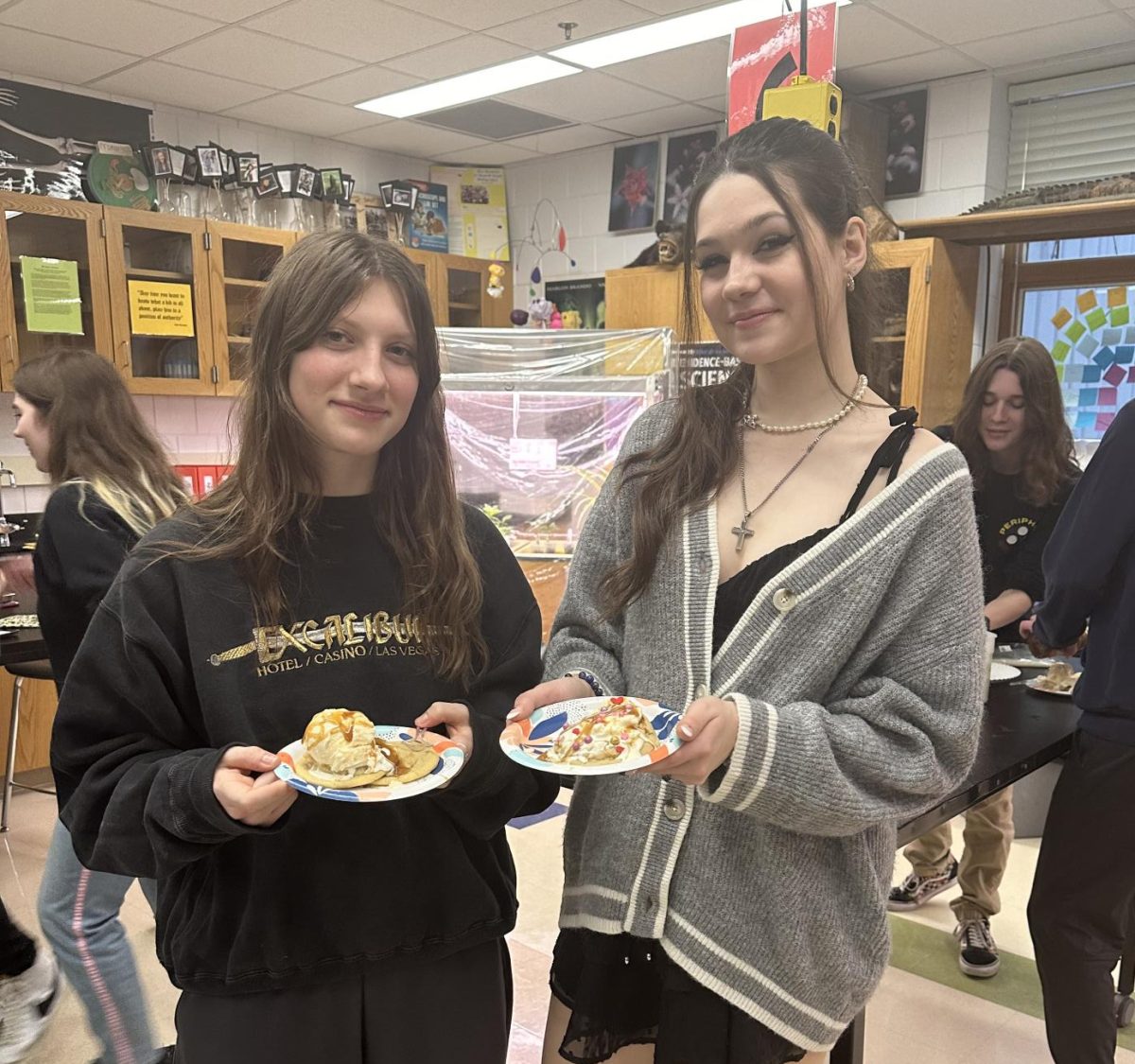 Seniors Madelyn Elzen and Gaby Miller help students bake cookies to create cookie ice cream sundaes. They love spreading the joy of baking to others and expressing creativity. 