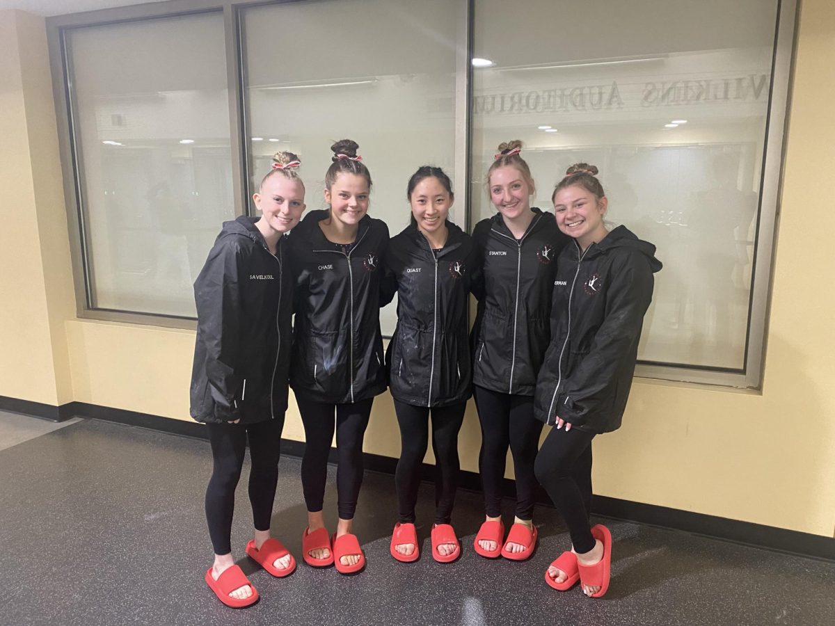 Senior Abbey Savelkoul, senior Zoe Chase, junior Liby Quast, senior Chloe Stanton and senior Ava Biederman about to get ready for the gymnastics state championship at Wilkins Auditorium Feb. 24. The team has worked hard to get to this point and are ready to give everything they have got into this final hurrah.