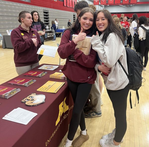 Juniors Madison Olson and Ava Aspengren exploring opportunities at the College Fair. Standing next to University of Minnesota booth listening in on  future career paths.