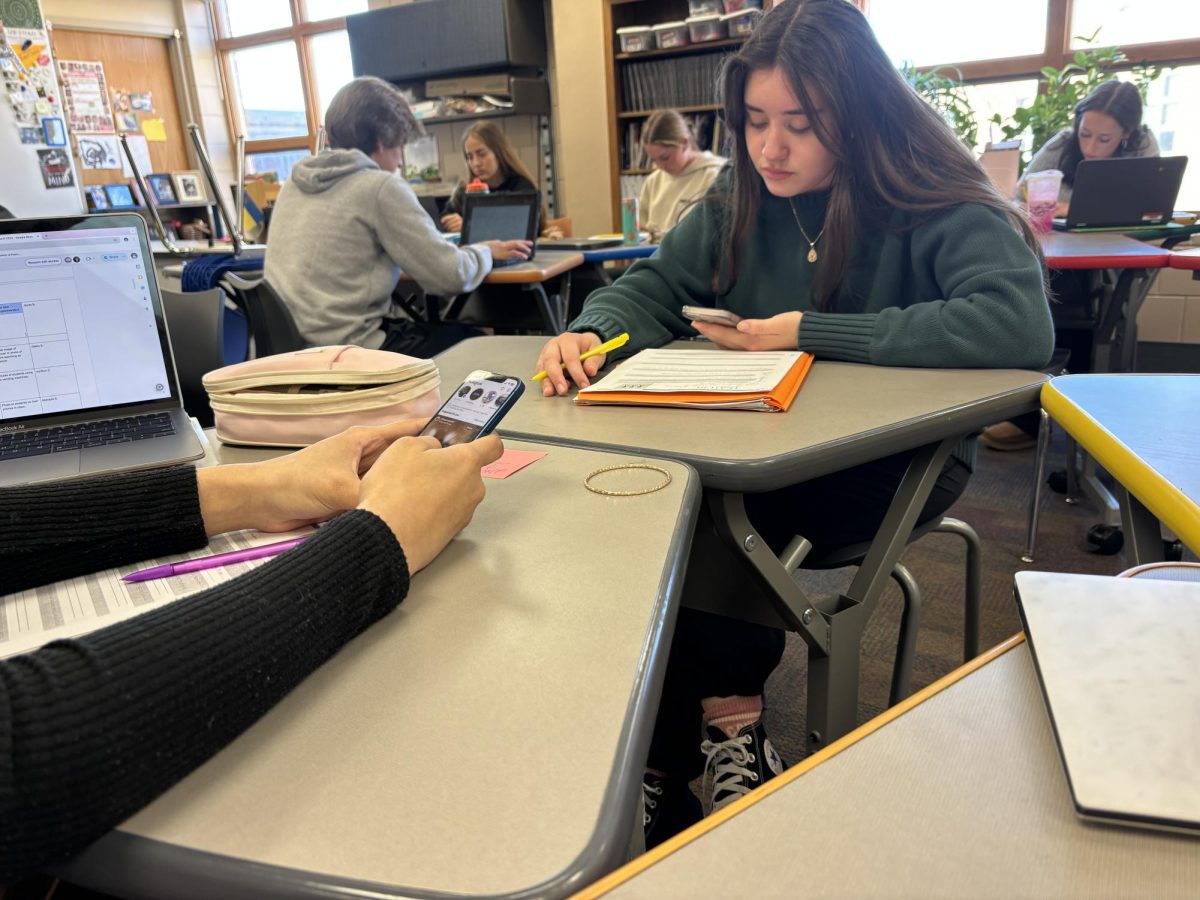 Juniors Briana Barreiro and Jayda Boutchee example what they have seen in classes. Phone use during school hours has become normalized. 