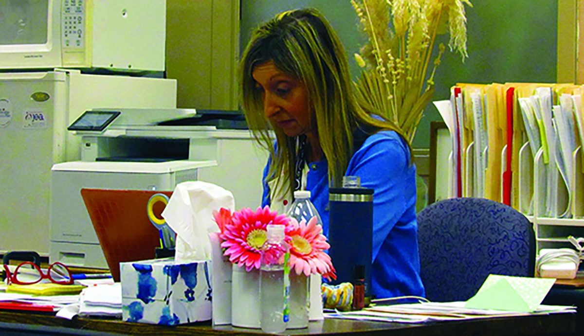 Pathways Coordinator Rachel Steil is busy and hard at work, She is cutting up paper to help her teach her class the next day.