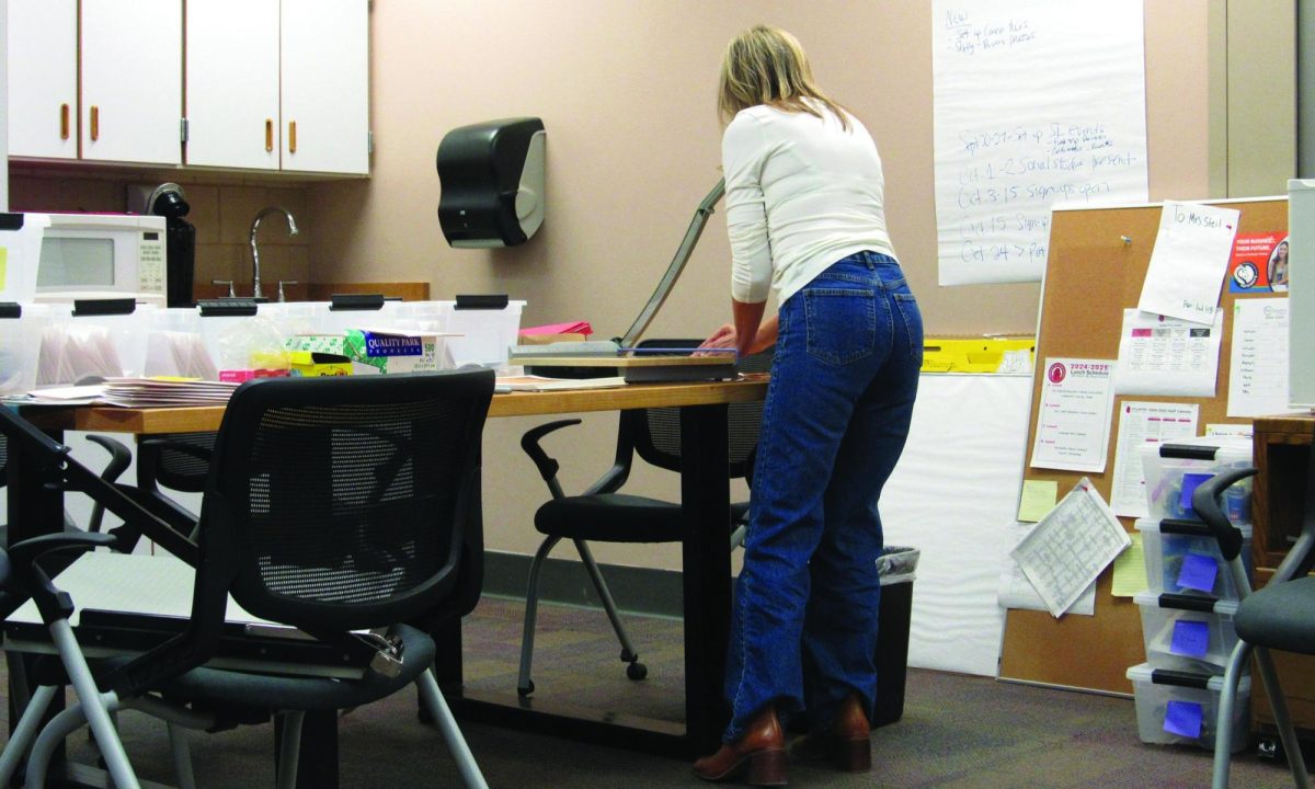 Pathways Coordinator Rachel Steil is busy and hard at work, She is cutting up paper to help her teach her class the next day.