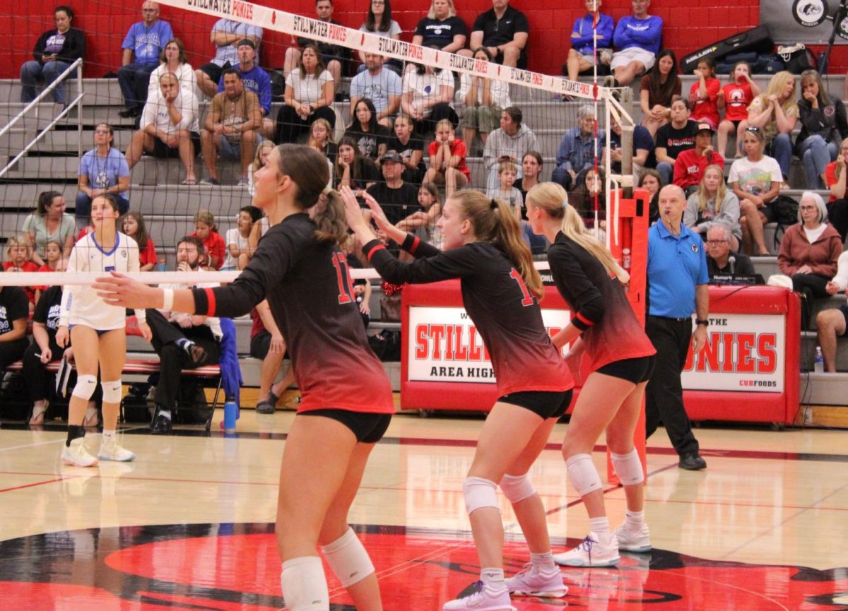 Varsity Juniors, Courtney Peters, Addison Brekke and Cecelia Spaeth get into their formation as their teammate serves the ball. The Ponies lost this point, the score is now 12-14.