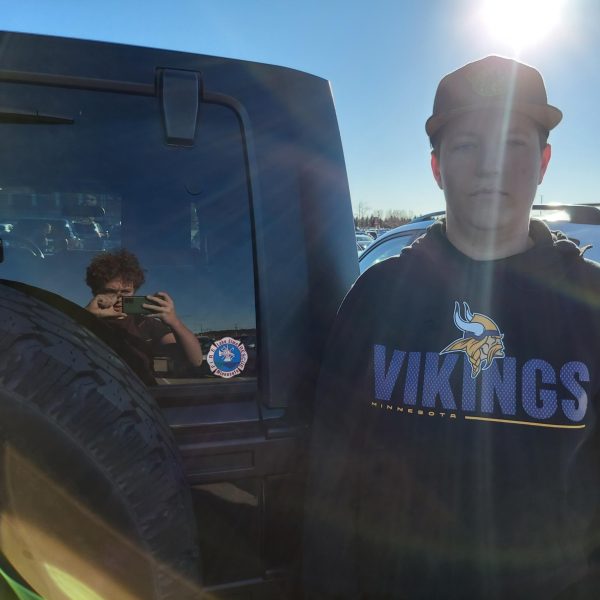 A man poses for a photo next to his car with a firefighting decal