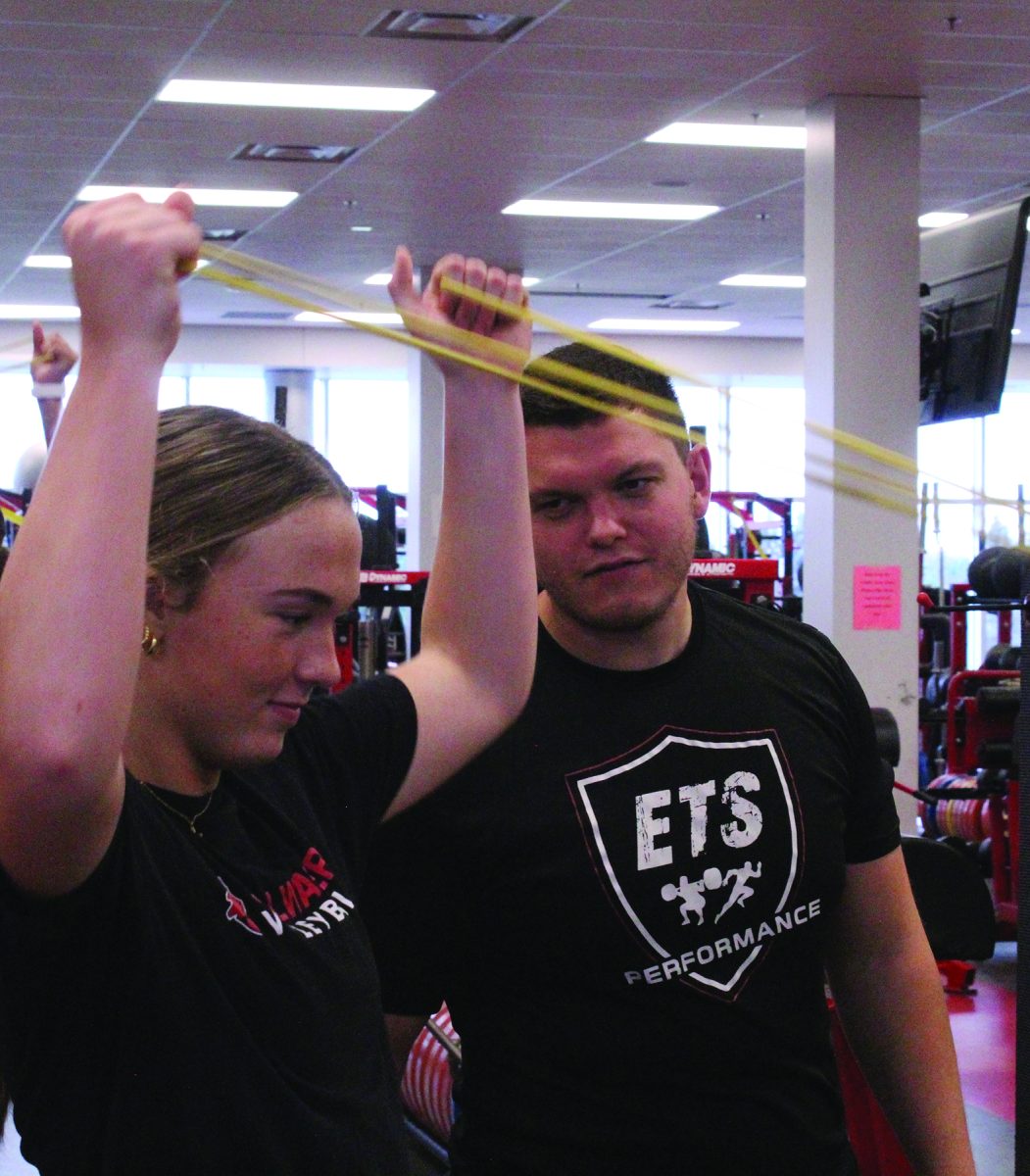 While athletes are completing workouts, coach Lucas Garbe connects with them to create strong relationships. Garbe shares a laugh with sophomore Josie Hellyer.
"Coach Garbe is a great coach, I enjoy seeing him in the gym everyday,"  junior Isaac Sainsbury said.