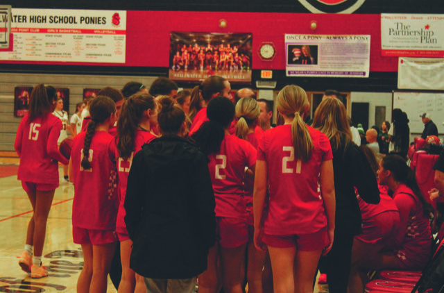 The girls basketball team gets into a big huddle, for one captain to give a couple word for inspirement. this helps the team out to have a clear head and are focused and ready to play basketball
