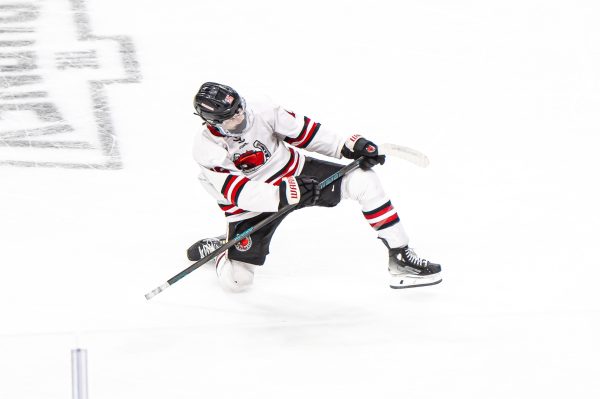 Sophomore Luca Jarvis scores a goal in the state quarterfinal game against Andover on March 13. He celebrates down the ice towards the student section.