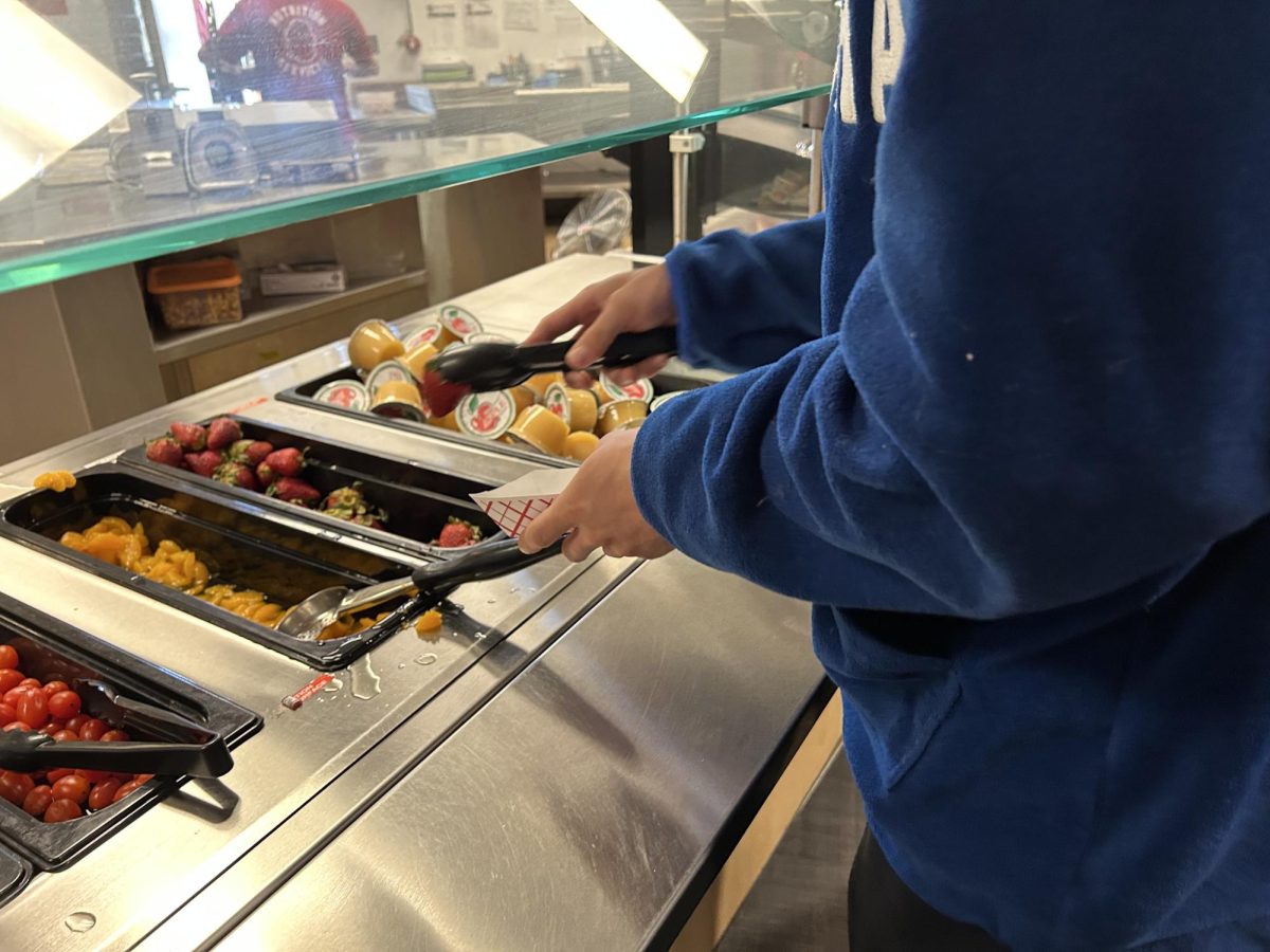 Students grab fruit from the lunch line which is free to all students. SAHS is not affected by the cuts and lunch will continue to be free.