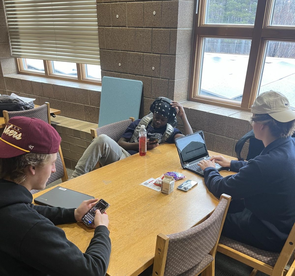 Students Kevin Wavamuno, Ryan Rees, and Cameron Gallaway in the library taking online PSEO courses. This is another con of PSEO, students not doing their assignments. One out of three students are on task. 