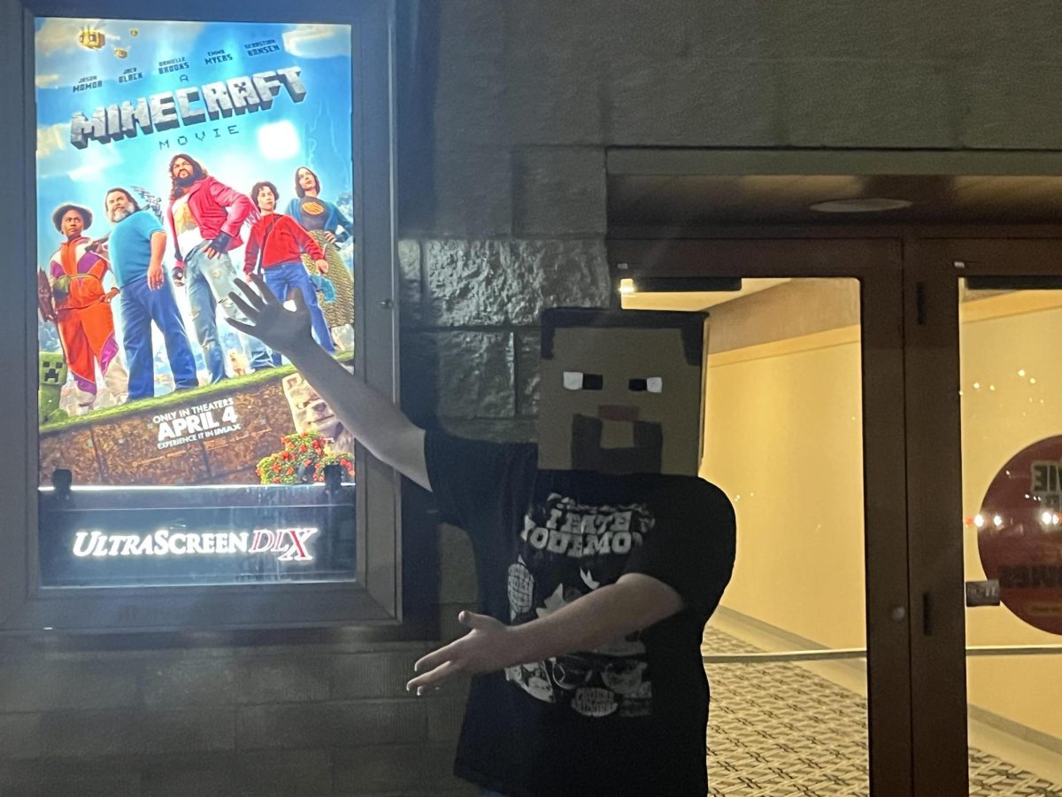Alumni Dakota Ostlie shows off 'A Minecraft movie' poster from Marcus Theater. Ostlie was laughing the whole time during the movie from all the funny jokes.