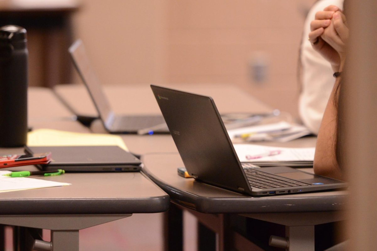 Students working with personal computers to complete their work in class