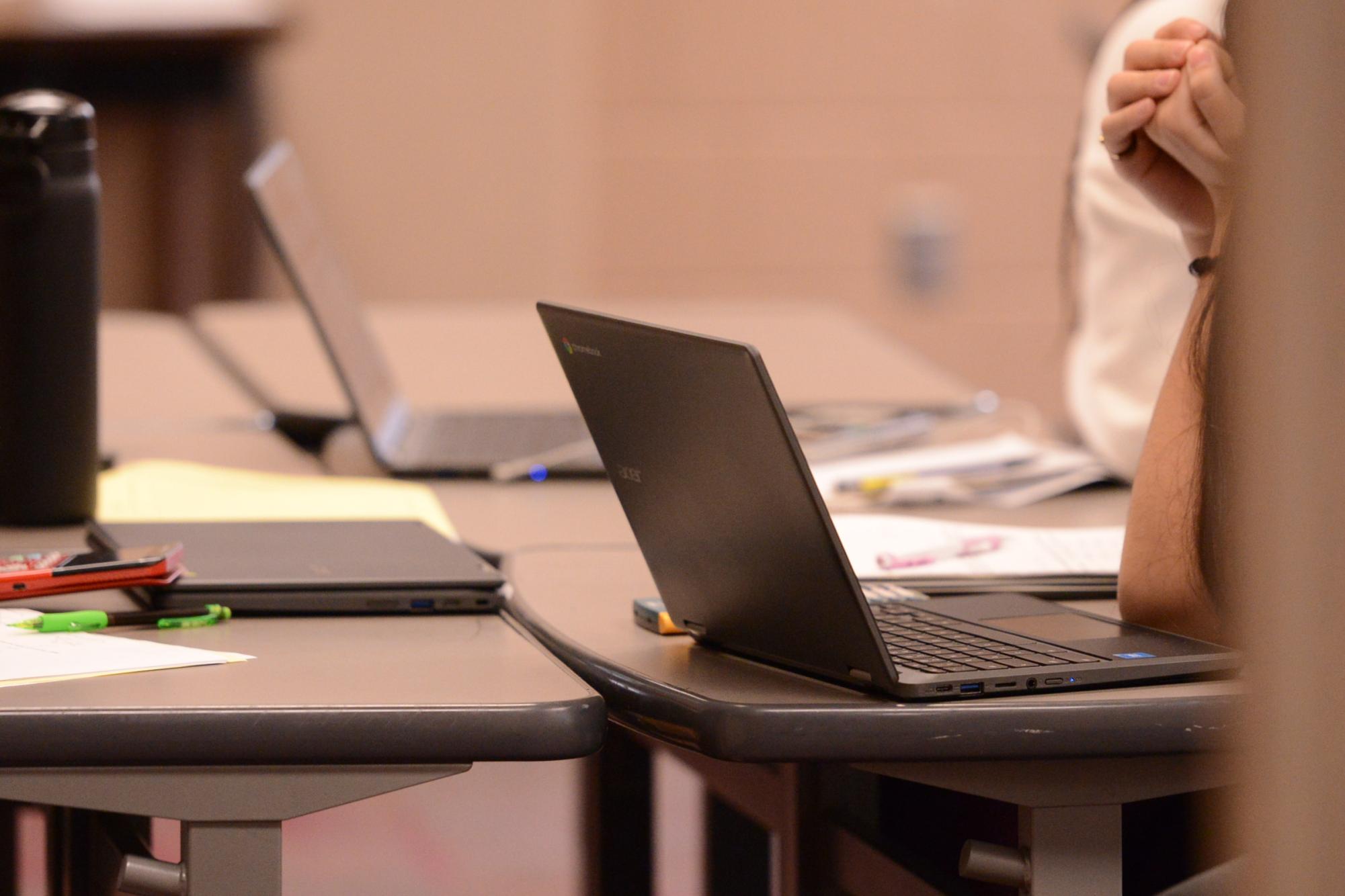 Students working with personal computers to complete their work in class