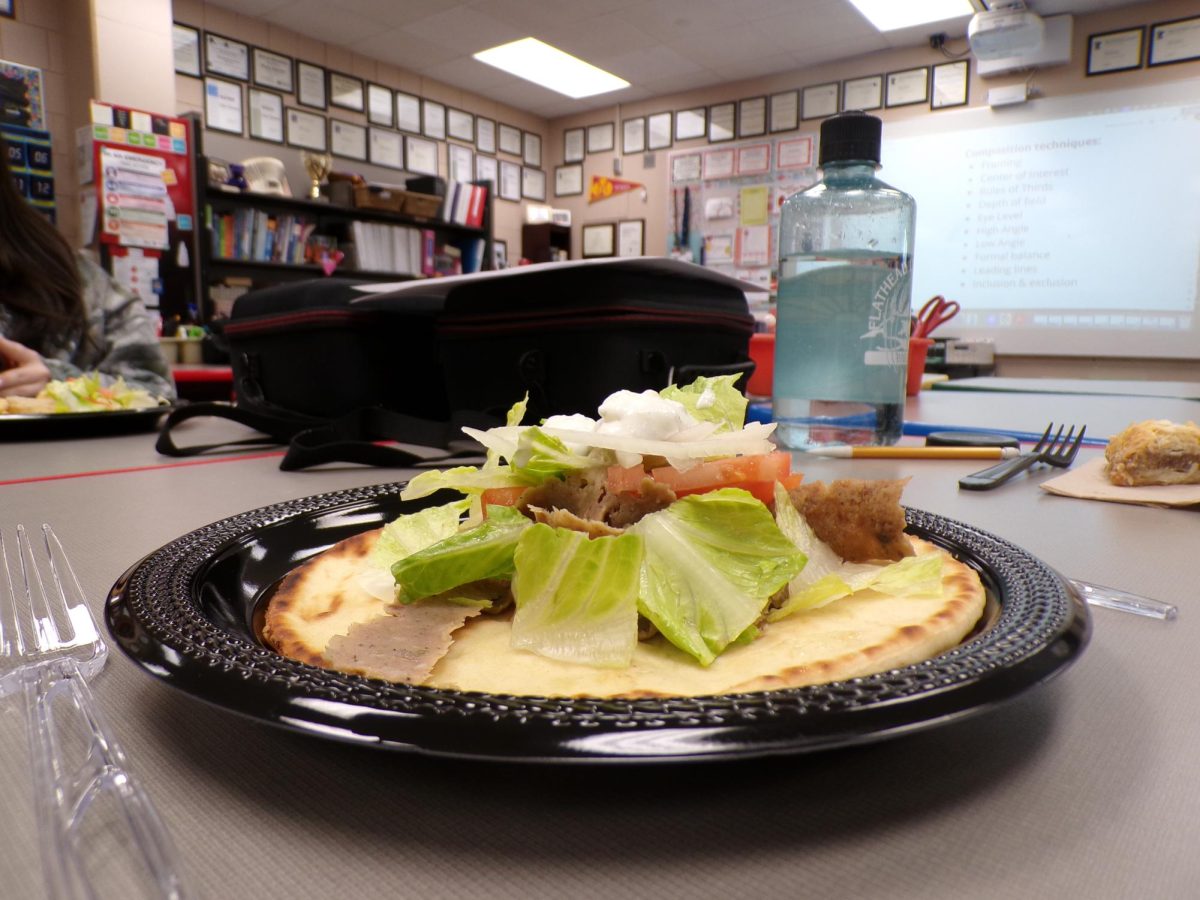 A gyro stacked with lamb, lettuce, tomato, onion and tzatziki. Simple layers coming together in one handheld wrap.
