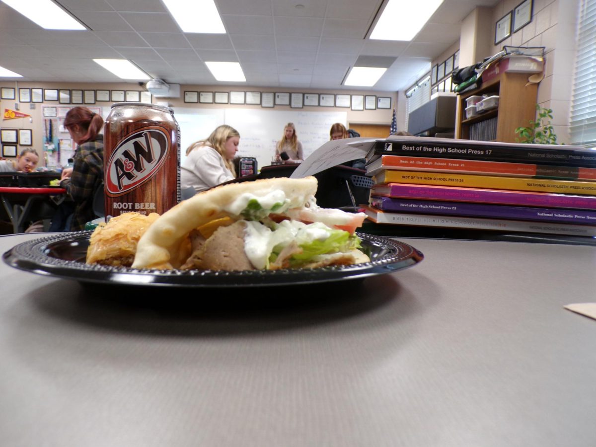 The gyro and baklava are arranged side by side. Fresh lettuce brings a crisp bite while the baklava adds a warm, syrupy cinnamon sweetness.