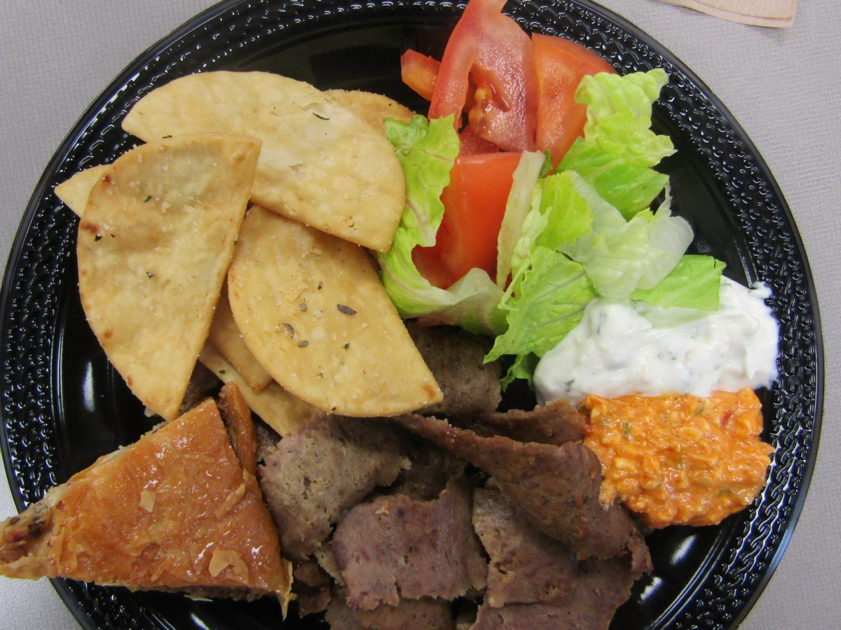 A lamb gyro plate from Dino’s is served with fresh tomatoes, lettuce, pita chips, tzatziki, spicy feta dip, and baklava.
