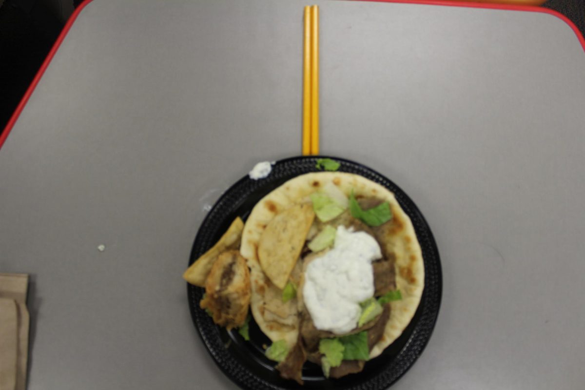 A gyro is highlighted as lines in the photo lead the eye toward the dish. Paired with pita chips, it offers the perfect crunch.