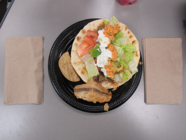 A lamb gyro from Dinos with lettuce, tomatoes, tzatziki sauce, and spicy feta sauce.  