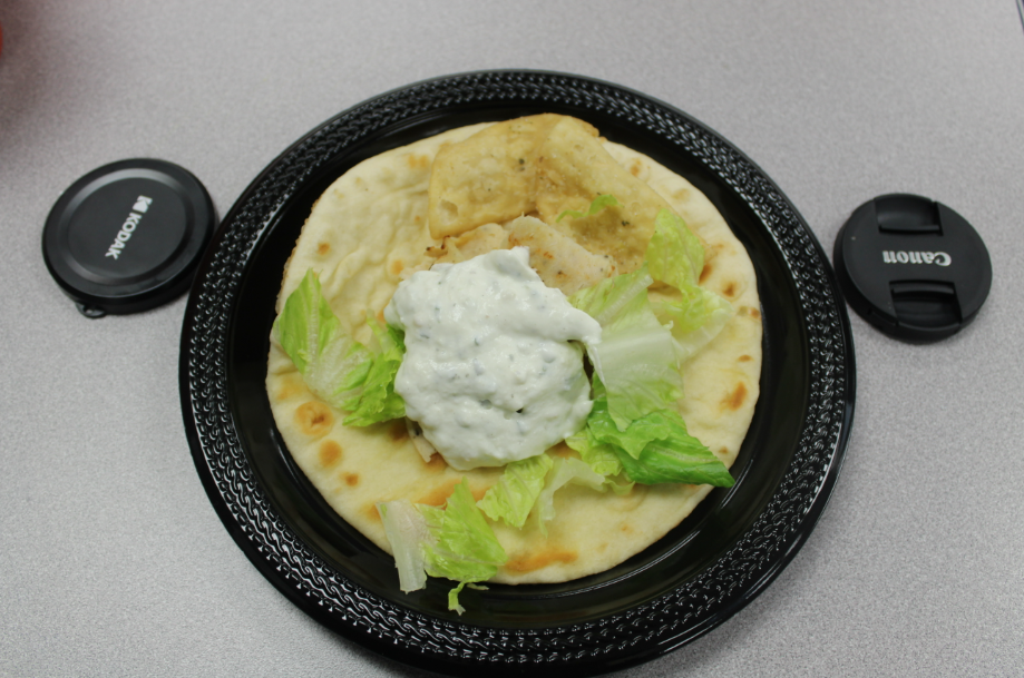 A shot of a delicious gyro in between two camera lens covers. This traditional delicacy tasted tangy and well seasoned.