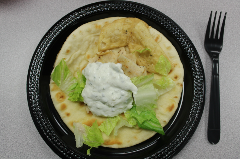 This picture contains a Greek styled gyro with pita bread and stuffed with savory meat, fresh lettuce and smooth Tzatziki sauce. The gyro had a classic Greek flavor with well seasoned meat and cool and fresh toppings.