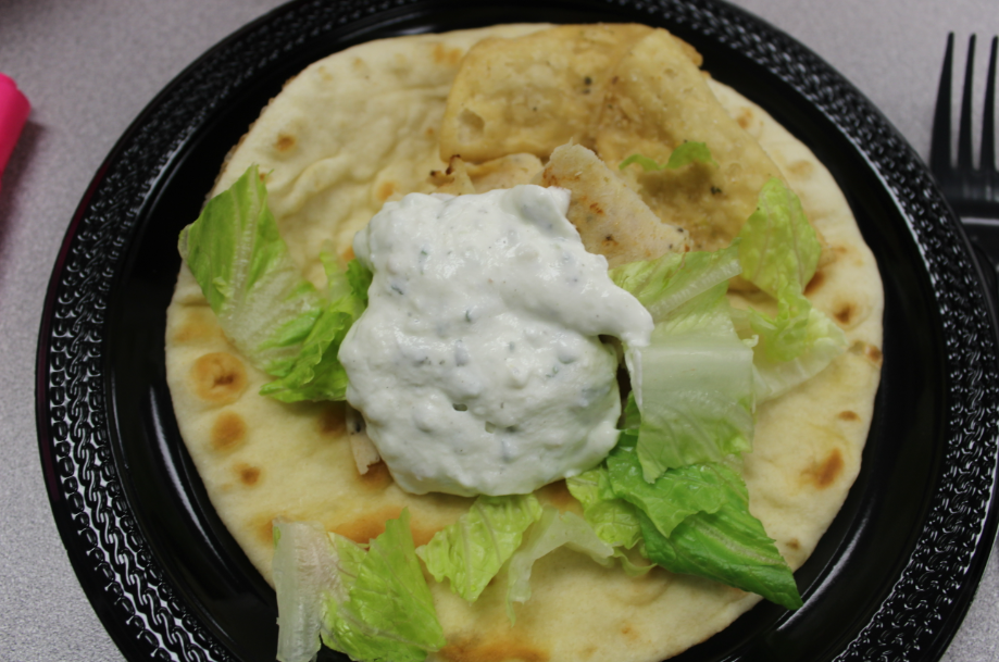A zoomed in photograph of a delightful stuffed gyro. It is a nutritious favorable mediterranean meal.  